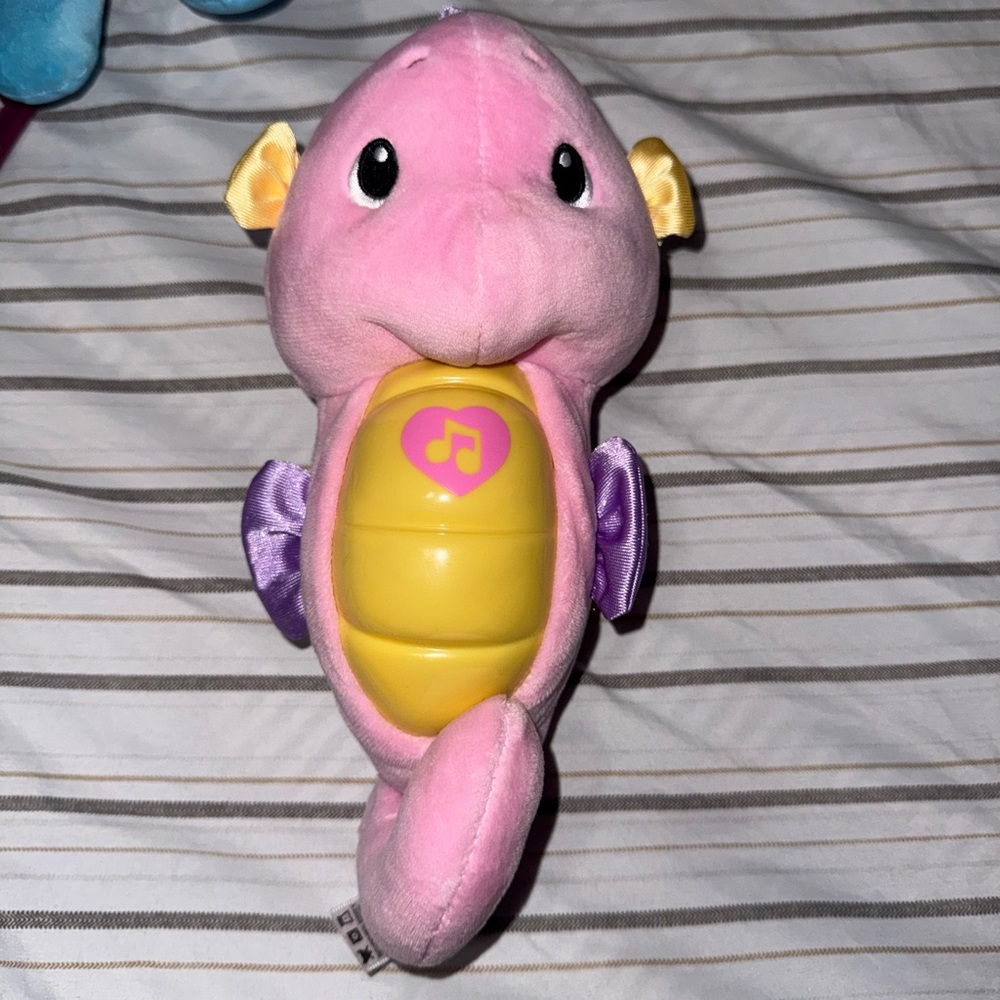 Fisher-Price Soothe & Glow Seahorse musical plush toy in pink.
